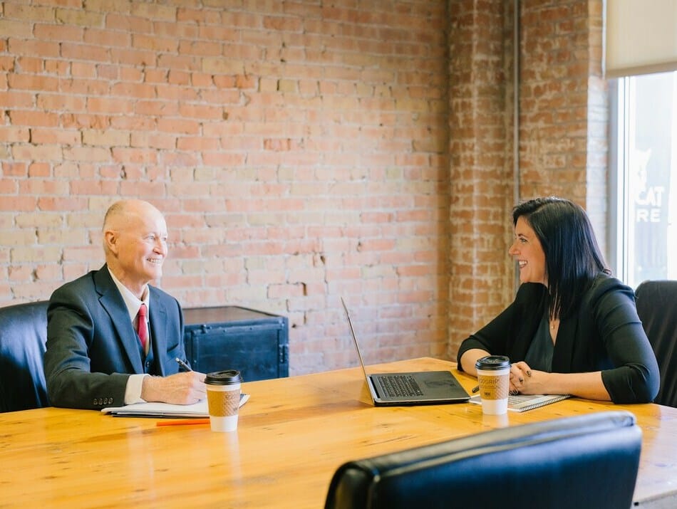 A man and a woman having a conversation at a table.