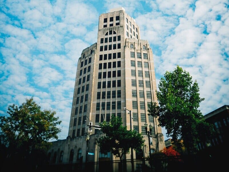 Office tower against a blue sky with clouds.