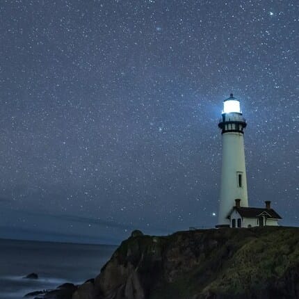 An illuminated lighthouse at night.